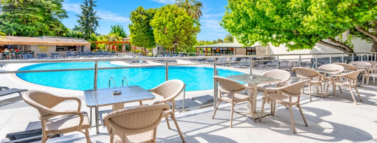 piscine extérieure de l'hôtel avec table et chaise en terrasse