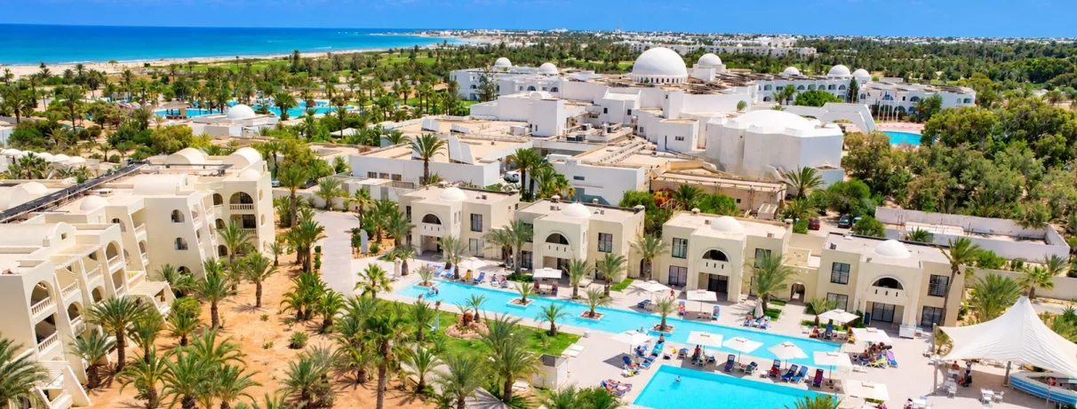 Complexe hôtelier César Thalasso à Djerba, Tunisie, avec piscines turquoises, architecture orientale et plage méditerranéenne.