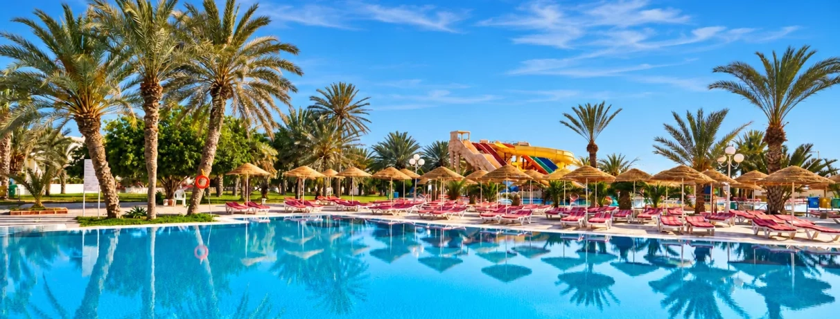 piscine et palmiers au complexe hôtelier Quatre Saisons à Djerba, Tunisie.