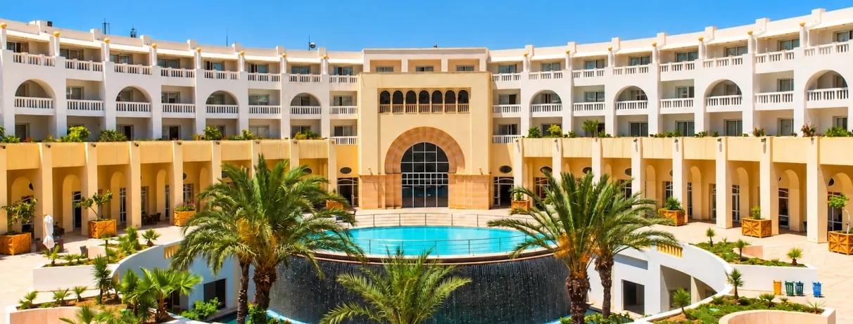vue de la façade de l'hôtel avec palmier de jour