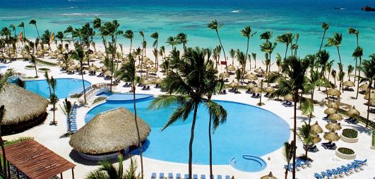 piscine avec palmiers et mer en arrière plan