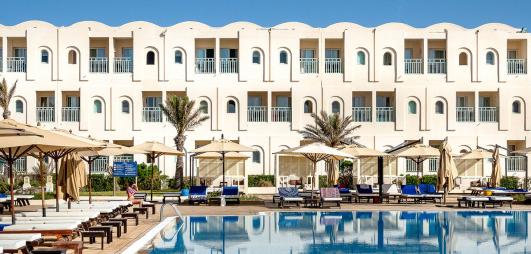 bâtiment blanc hôtel avec la piscine devant