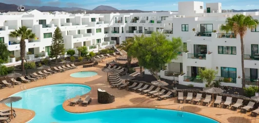 Une vue sur le complexe hôtelier, montrant la terrasses et la forme de la piscine.