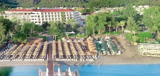 Vue du complexe hôtelier dans la verdure avec la plage en bord.