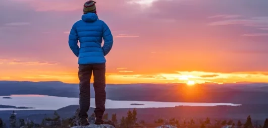 homme contemplant le soleil de minuit en été en laponie finlandaise à levi lors d'un séjour au levi spa
