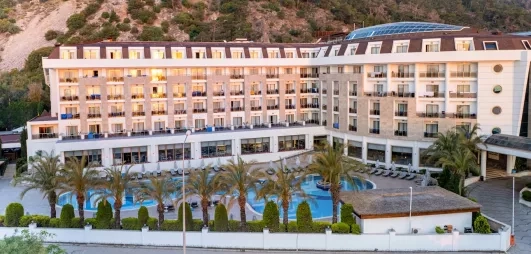 Vue de l'ensemble du complexe hôtelier avec ses palmiers et sa piscine.