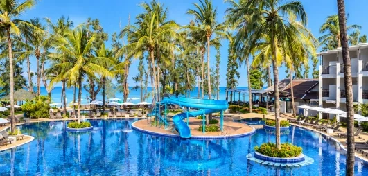 Vue piscine ave immeuble et cocotiers