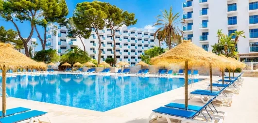 vue de la grande piscine extérieur de l'hôtel avec parasols en paille