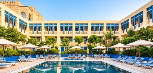 piscine extérieure équipée de transats et bâtiment de l'hôtel