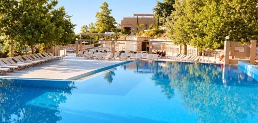 Vue de la piscine extérieur de l'hôtel au milieu du jardin.