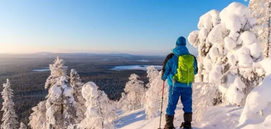 Randonneur contemplant un paysage enneigé lors d'un séjour au Mondi Club Sodankylä en Laponie.