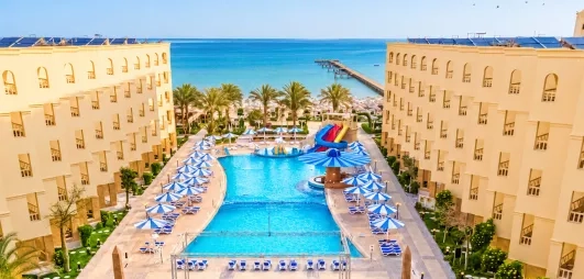 vue aérienne avec piscine plage avec transats et mer turquoise, toboggans au AMC Royal à Hurghada, Egypte