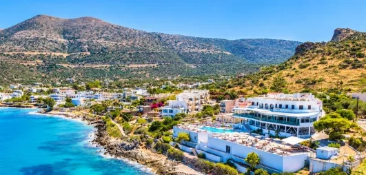 vue aérienne de l'hôtel donnant sur les rochers et la plage, la piscine et le bâtiment