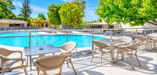 piscine extérieure de l'hôtel avec table et chaise en terrasse