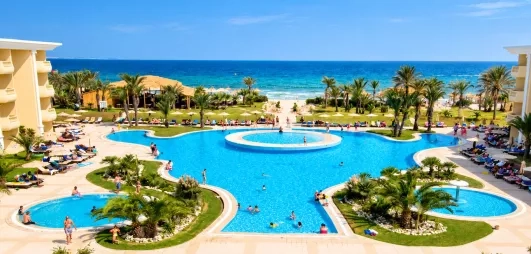 Vue panoramique des bassins extérieurs et accès plage privée du Royal Thalassa Monastir, Tunisie.