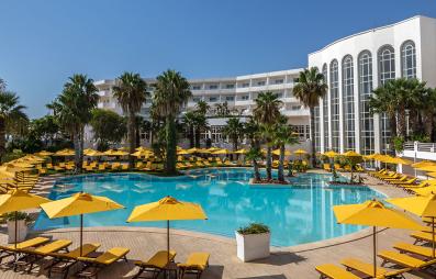 piscine avec parasols jaunes et bâtiment hôte