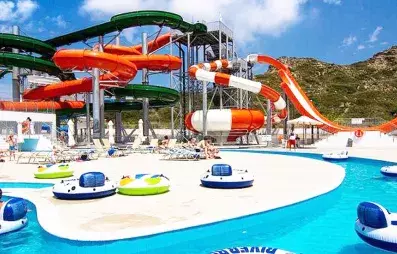 Grand aquapark avec piscine, transats, sous le soleil, montagne, personnes dans des bouées