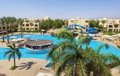Grande piscine lagon, toboggans aquatiques et palmiers au Mondi Club Stella Gardens Resort & Spa, Hurghada Égypte.