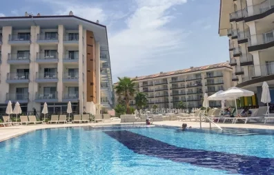 La piscine principale bordée de transats face aux bâtiments modernes de l'hôtel.