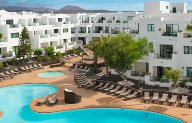 Une vue sur le complexe hôtelier, montrant la terrasses et la forme de la piscine.