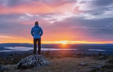 homme contemplant le soleil de minuit à levi en laponie en été 