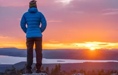 homme contemplant le soleil de minuit en été en laponie finlandaise à levi lors d'un séjour au levi spa