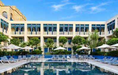 piscine extérieure équipée de transats et bâtiment de l'hôtel