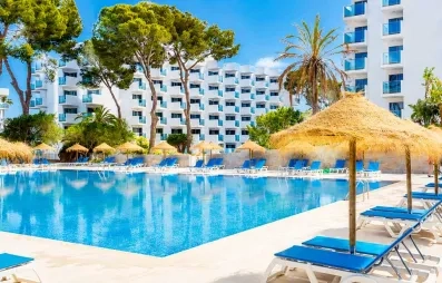 vue de la grande piscine extérieur de l'hôtel avec parasols en paille