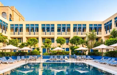piscine extérieure équipée de transats et bâtiment de l'hôtel