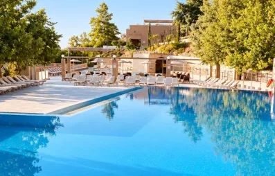 Vue de la piscine extérieur de l'hôtel au milieu du jardin.