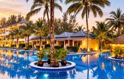 Une large piscine entourée de palmiers et de jardins tropicaux au coucher du soleil.