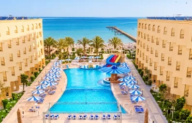 vue aérienne avec piscine plage avec transats et mer turquoise, toboggans au AMC Royal à Hurghada, Egypte