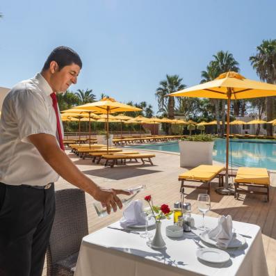 serveur devant une table dressée devant piscine