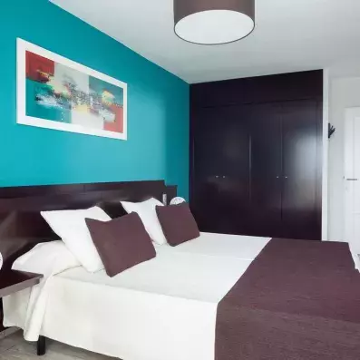 Une chambre moderne avec un grand placard sombre et un lit double élégant.