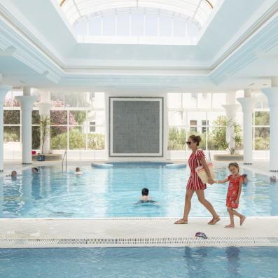 femme et enfant devant piscine intérieure