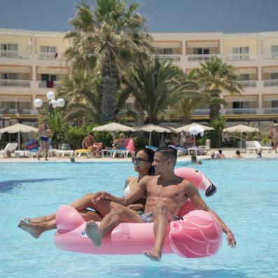 couple dans une bouée flamant rose dans piscine