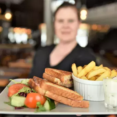 femme avec assiettes sandwich et frites