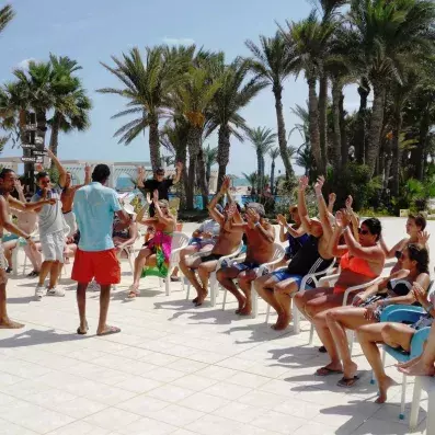 groupe assis sur chaises les mains levées