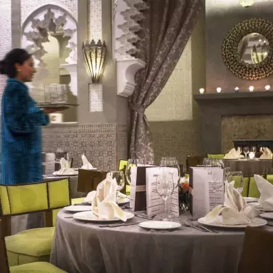 restaurant décoré en vert et gris avec tables et chaises et couverts