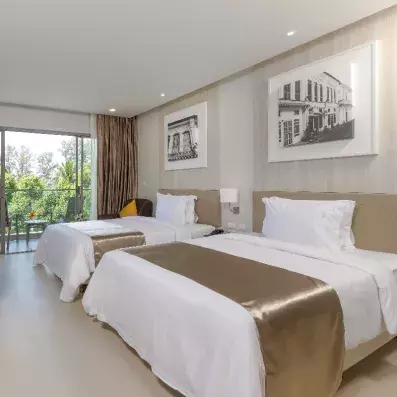 une chambre avec deux lits doubles et des tableaux