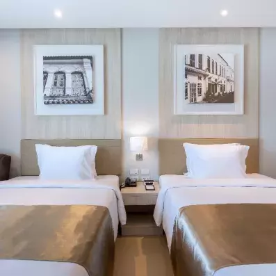 chambre avec deux lits simples et table de chevet au milieu