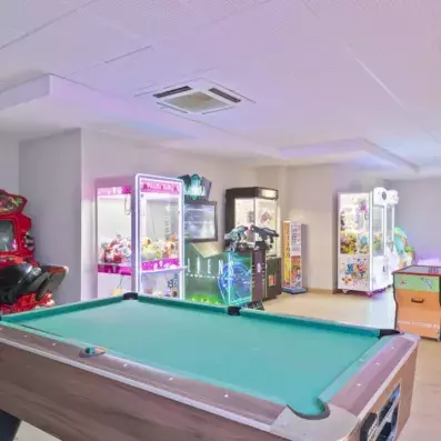 salle de jeux d'arcade avec une table de billard