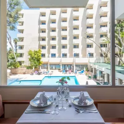table dressée vue sur la piscine de l'hôtel