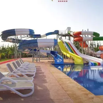vue sur la piscine avec tobogans colorés et transats au bord de la piscine