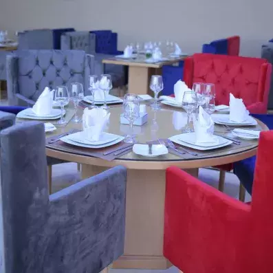 restaurant avec table  ronde et chaise capitonnées en rouge et gris