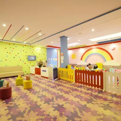 mini club pour enfants avec un arc en ciel peint sur le mur et un parc de jeuxjeu