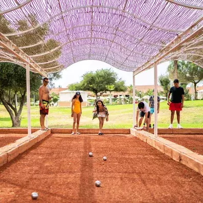 Une famille jouant au pétanque dans la partie loisirs de l'hôtel