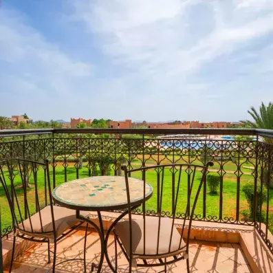 balcon à ciel ouvert avec vue sur le jardin et la piscine au fond