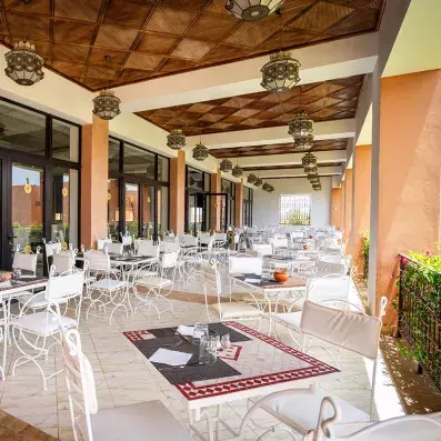 restaurant sur la terrasse avec tables en mosaïques et chaises blanches
