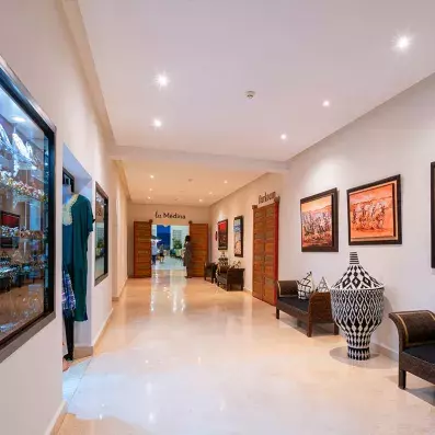 hall de l'hôtel, avec une boutique à souvenirs à droite, le café maure au fond et des tableaux décoratifs 